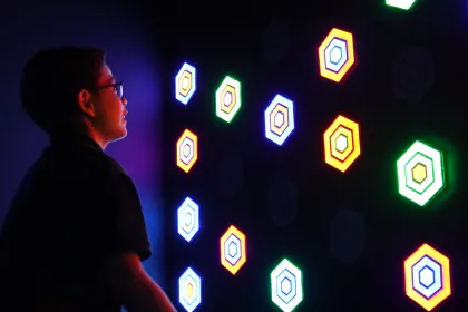 Un niño con anteojos alcanza los paneles iluminados