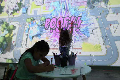 Una niña toca la proyección de un dibujo