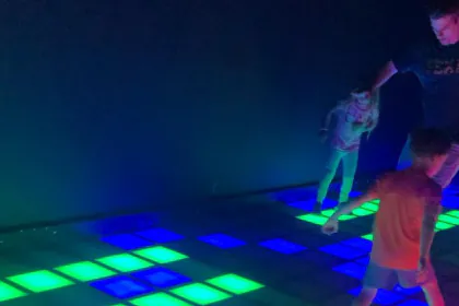 Un adulto y un niño sobre las baldosas iluminadas